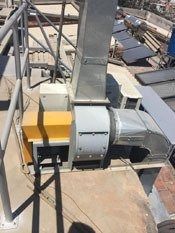 Conductos de climatización industrial en azotea y unidad de ventilación con tuberías metálicas y vigas de soporte.