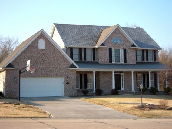 A large brick house with a basketball hoop in front of it