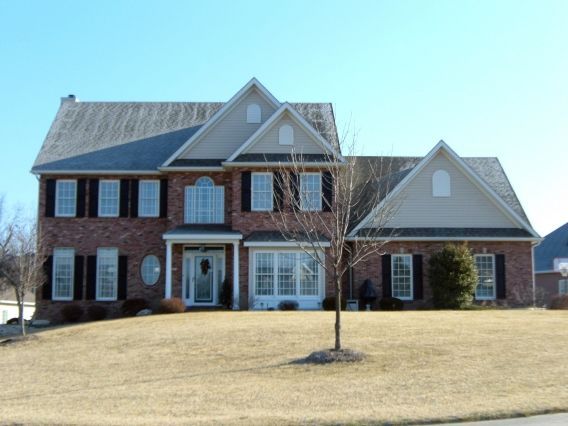 A large brick house with a tree in front of it