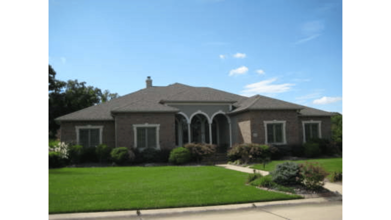 A large house with a lush green lawn in front of it