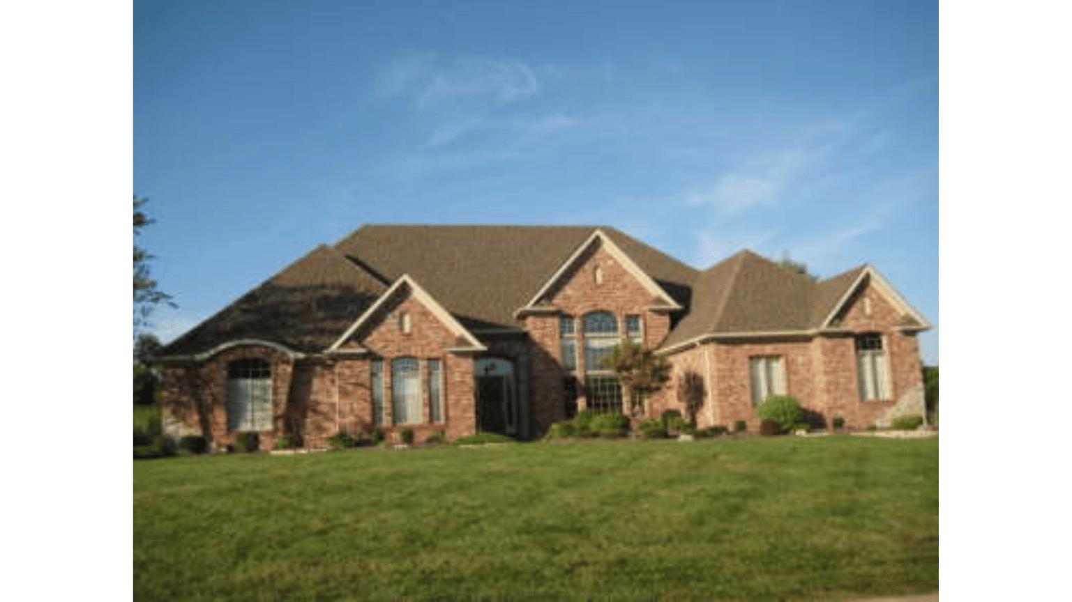 A large brick house with a brown roof