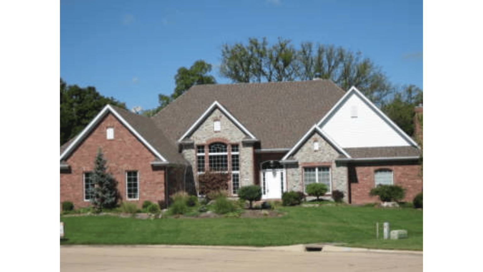 A large brick house with a brown roof and white trim