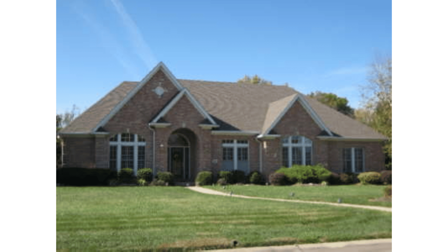 A large brick house with a brown roof