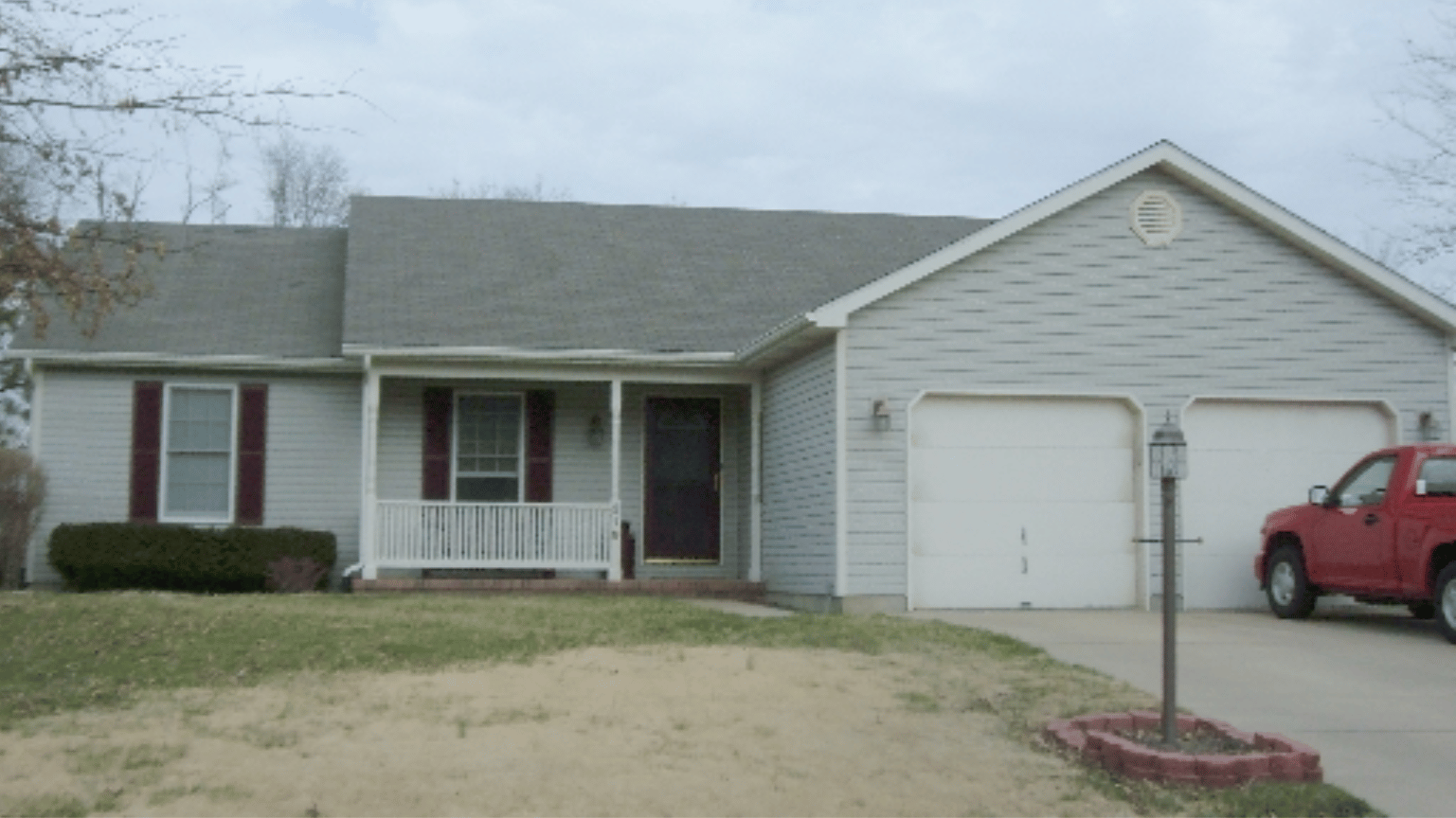 A red truck is parked in front of a house