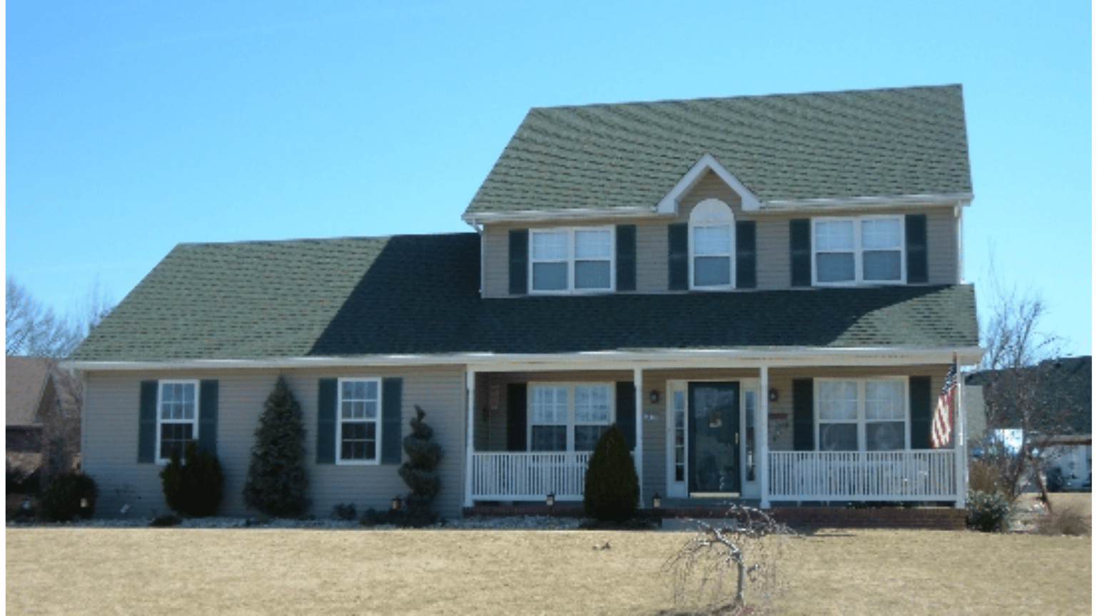 A house with a green roof and black shutters