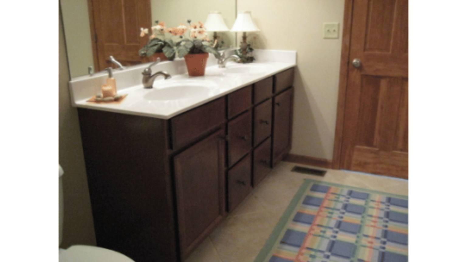 A bathroom with two sinks and a toilet
