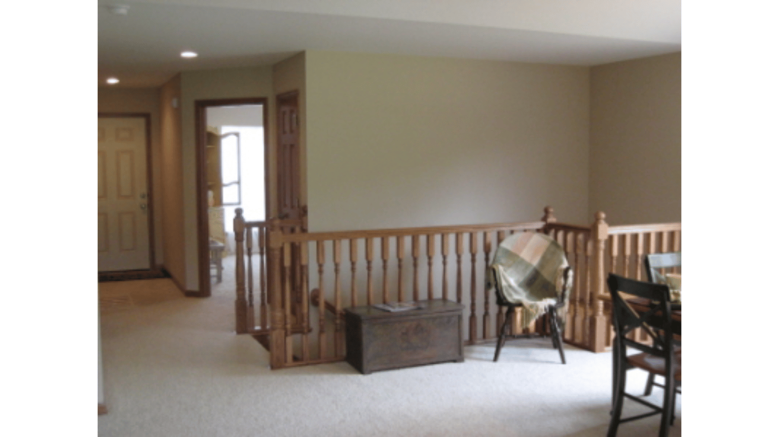 A room with a wooden railing and a chair