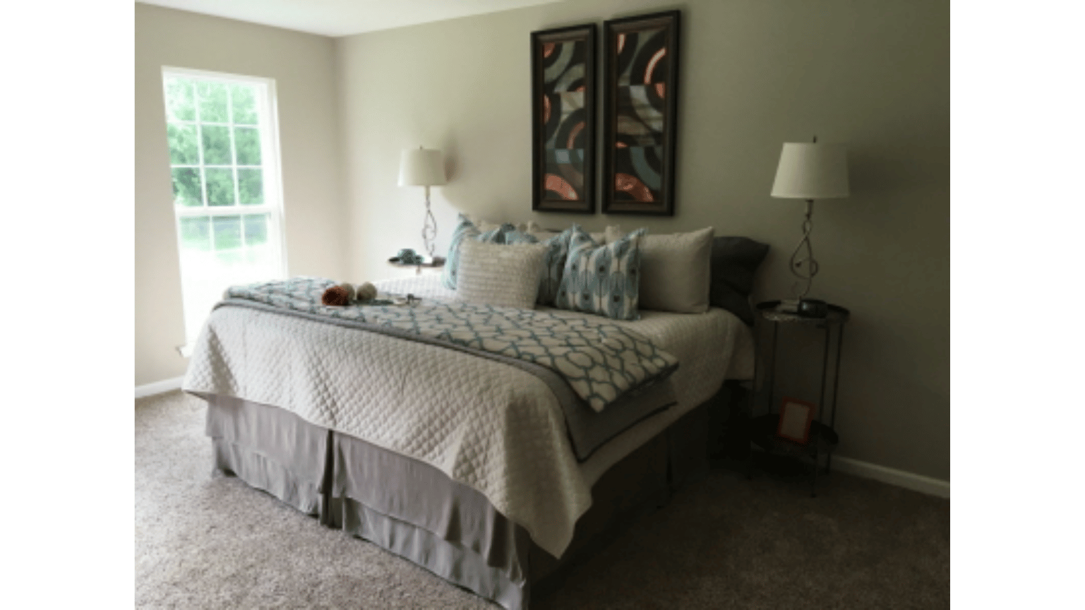 A bedroom with a large bed and two lamps