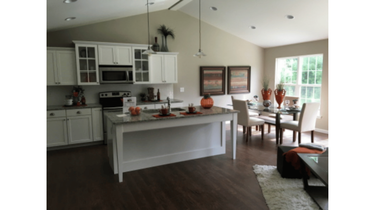 A kitchen with white cabinets and a large island in the middle