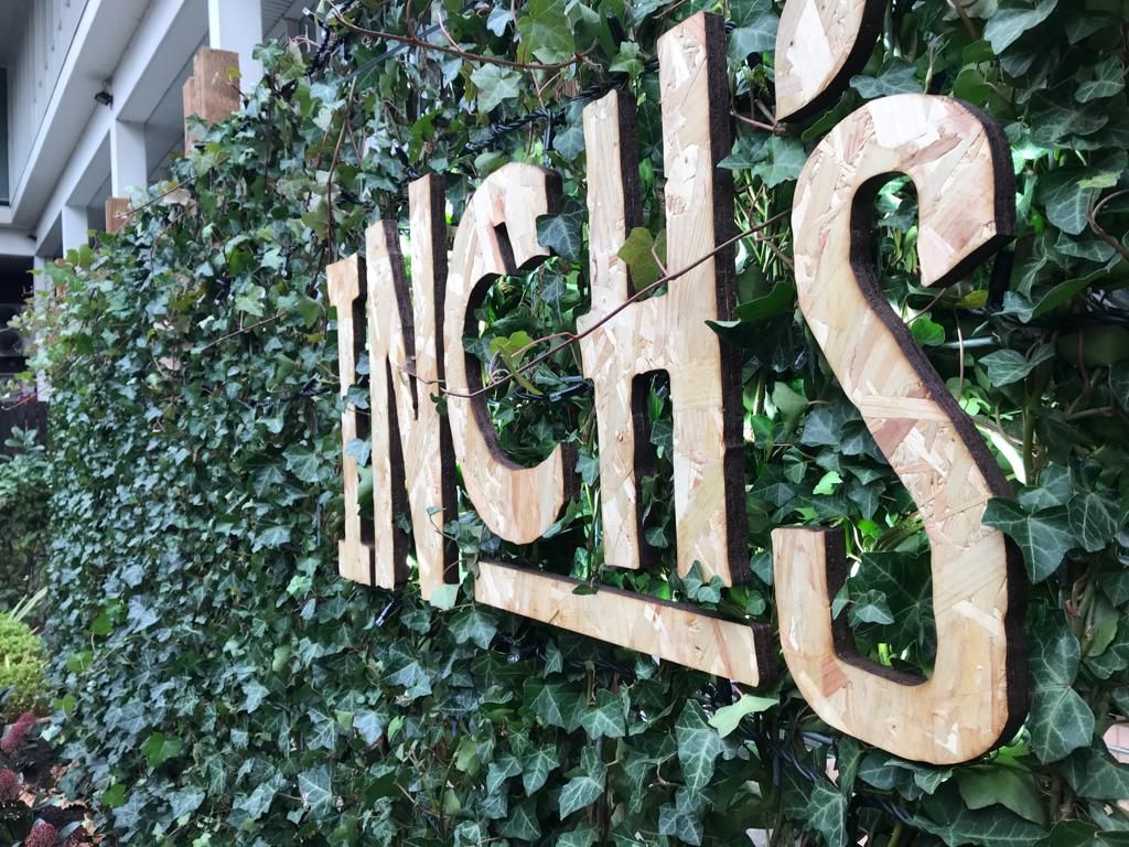 Inch's wooden cut lettering over ivy background side view
