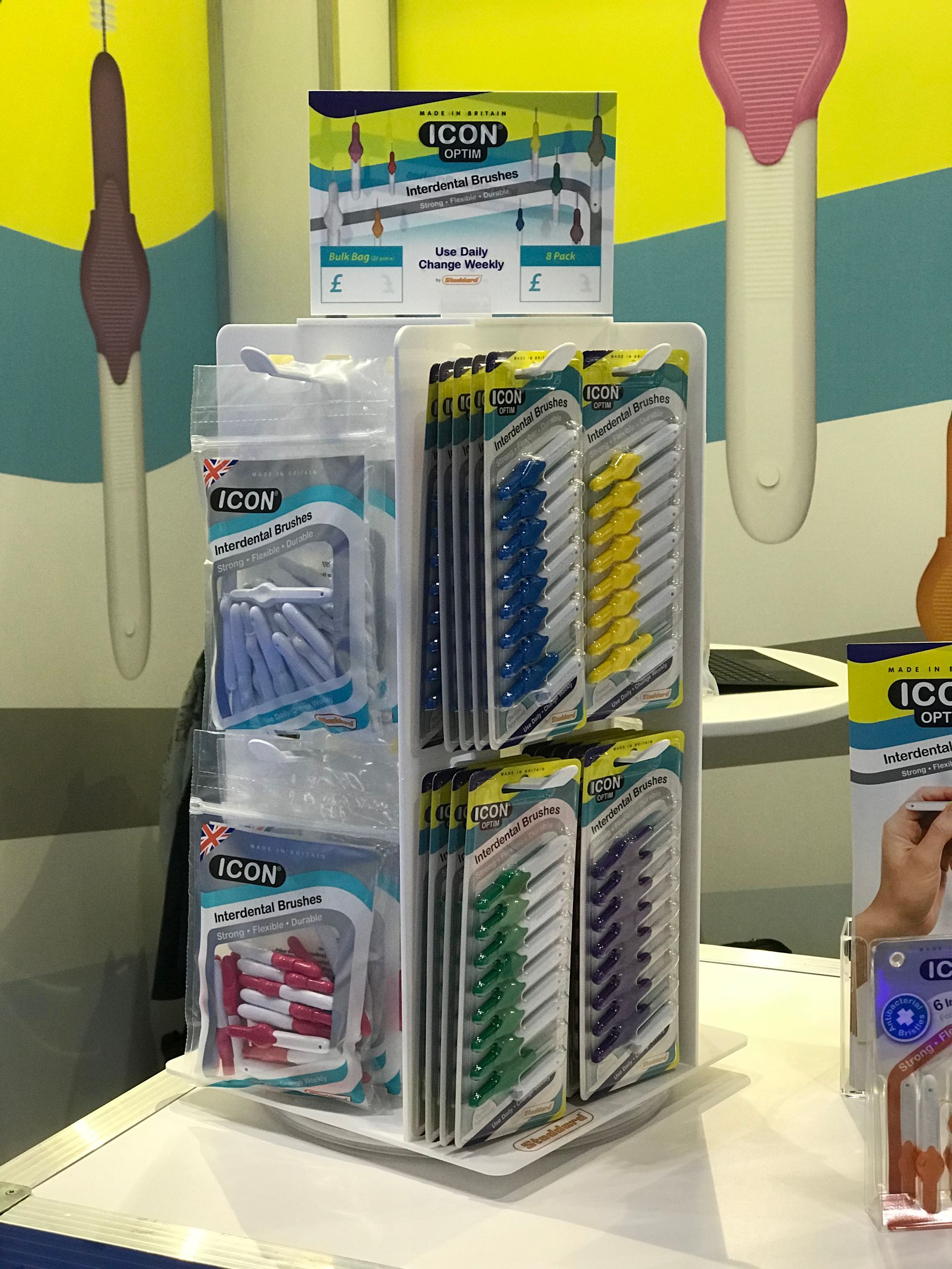 Acrylic manufactured rotating countertop point of sale unit for hanging packs of dental products