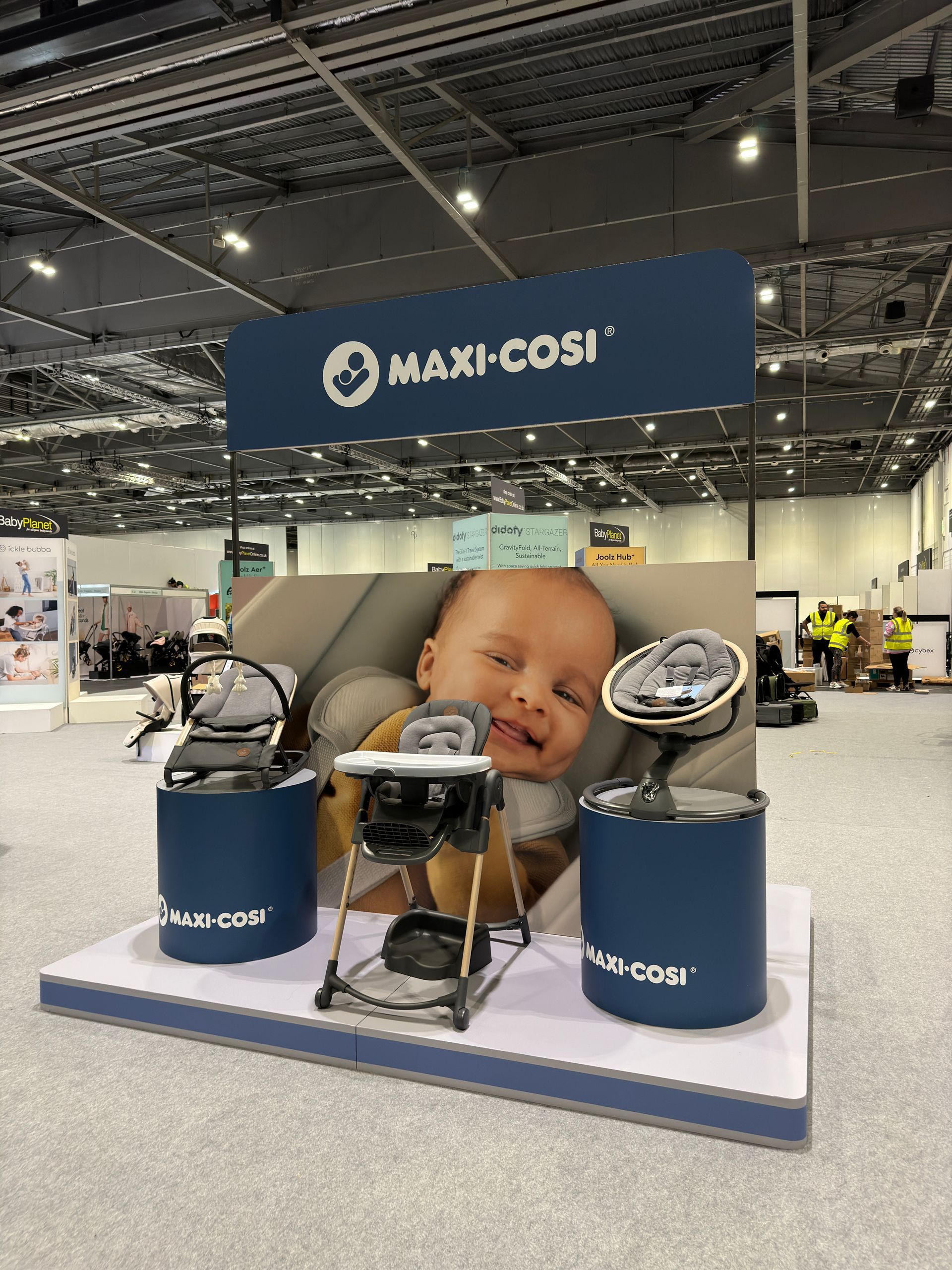 Maxi-cosi brand display with printed panel and branded product plinths