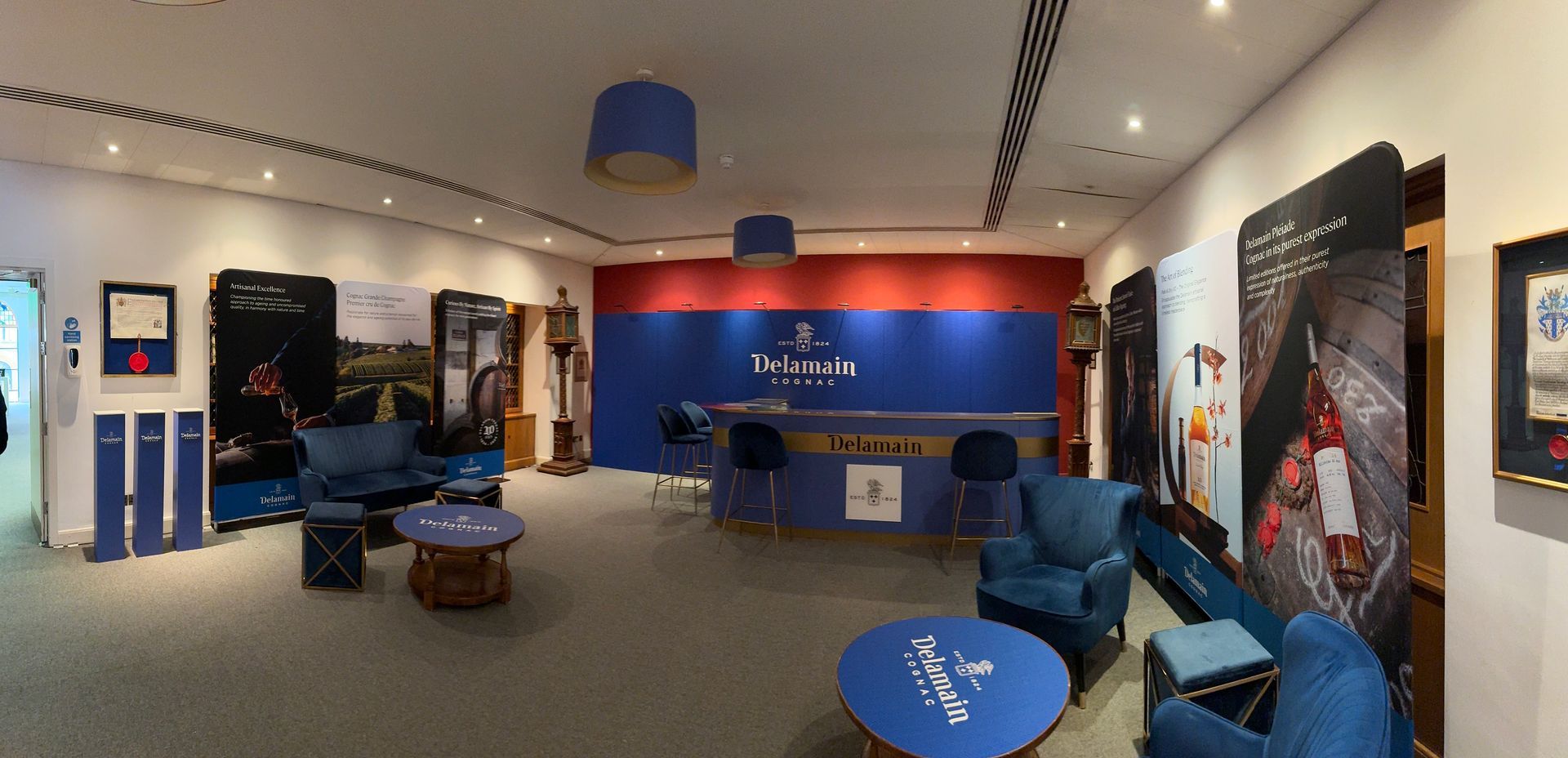 Various branded Delamain Cognac Promotional items including lounge bar, bar tables and printed fabric banners.