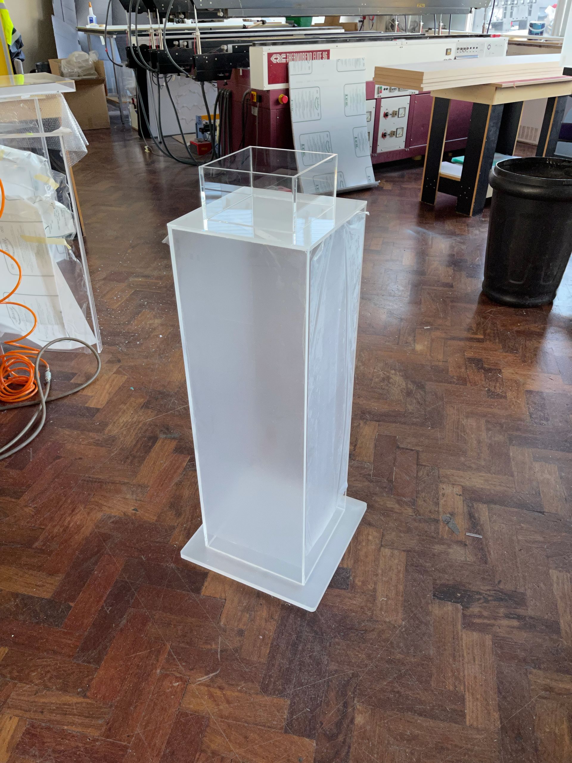 Acrylic clear rectangular box mounted on frosted acrylic base