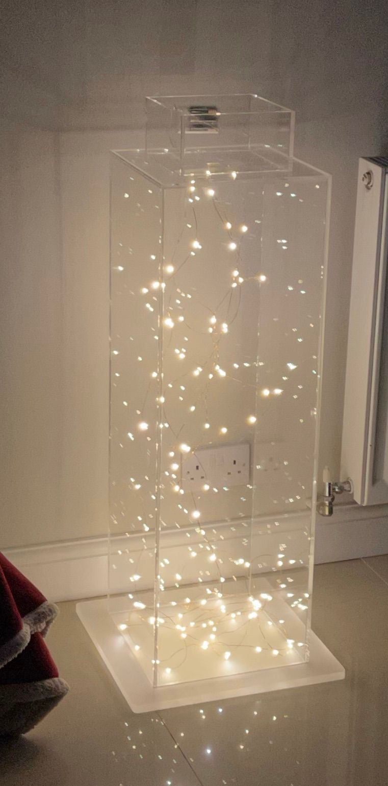 Acrylic clear rectangular box mounted on frosted acrylic base containing fairy lights