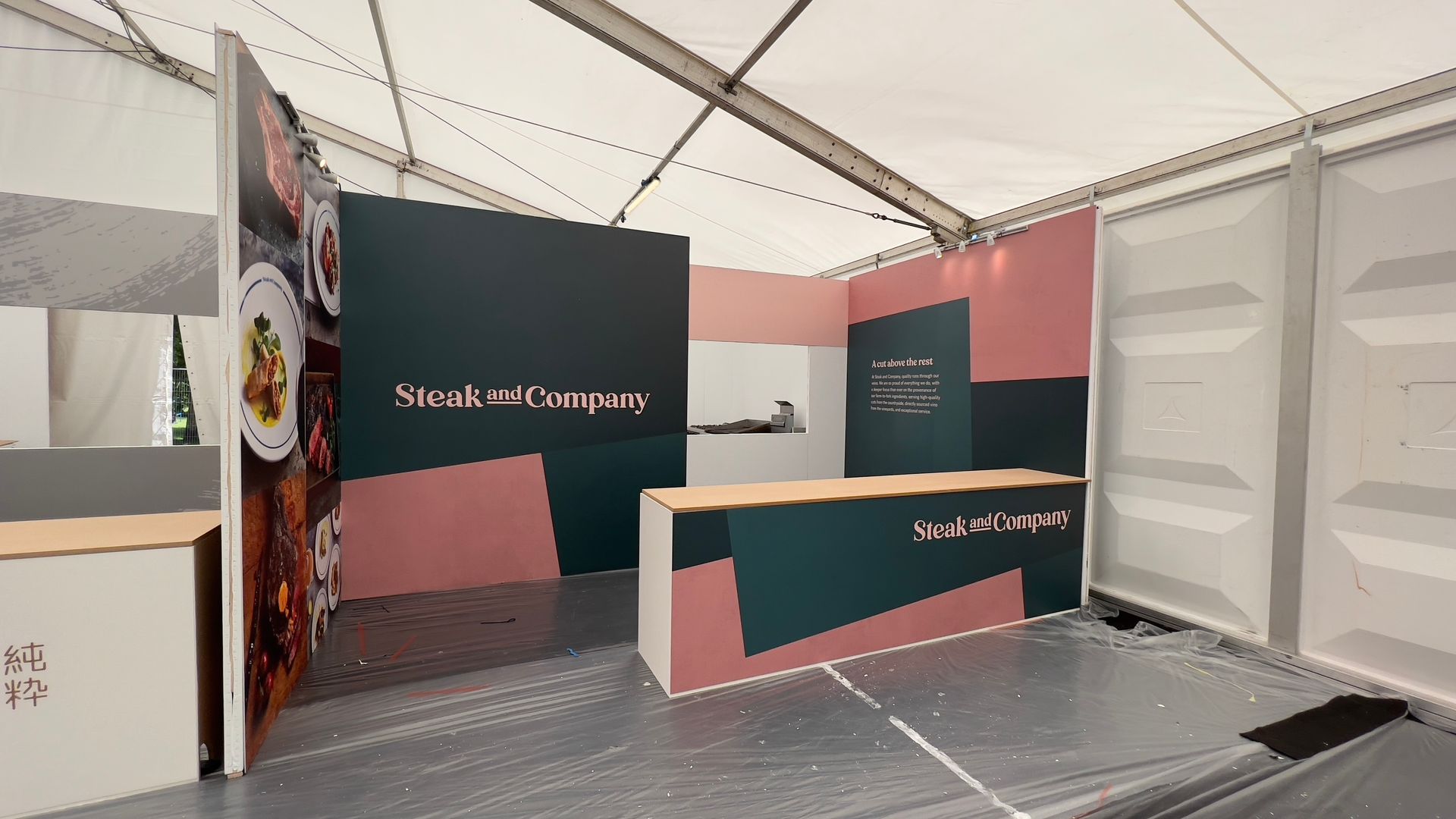 Exhibition stand counter for the Steak and Company showing large foamex printed panels of prepared food.