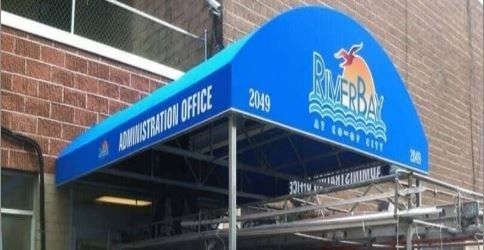 Blue awning over a building entrance reading “Admissions Office,” with a Ricebirds logo and the number 2063.