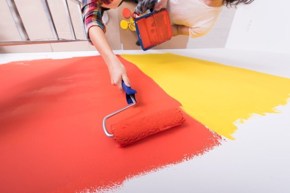 A Person Is Painting A Wall With A Roller — Ballina Painting Service In Bangalow, NSW