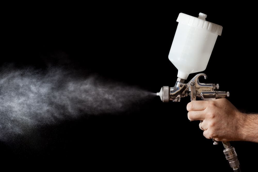 A Man Operates A Spray Gun, Releasing A Fine Mist Of Paint — Ballina Painting Service In Lennox Head, NSW