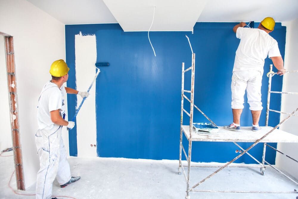Two Men Are Painting A Blue Wall In A Room — Ballina Painting Service In Lismore, NSW