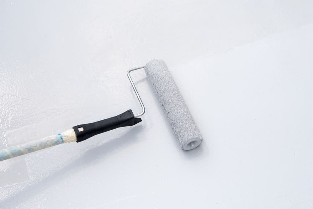 A Paint Roller Is Being Used To Paint A White Wall — Ballina Painting Service In Lennox Head, NSW