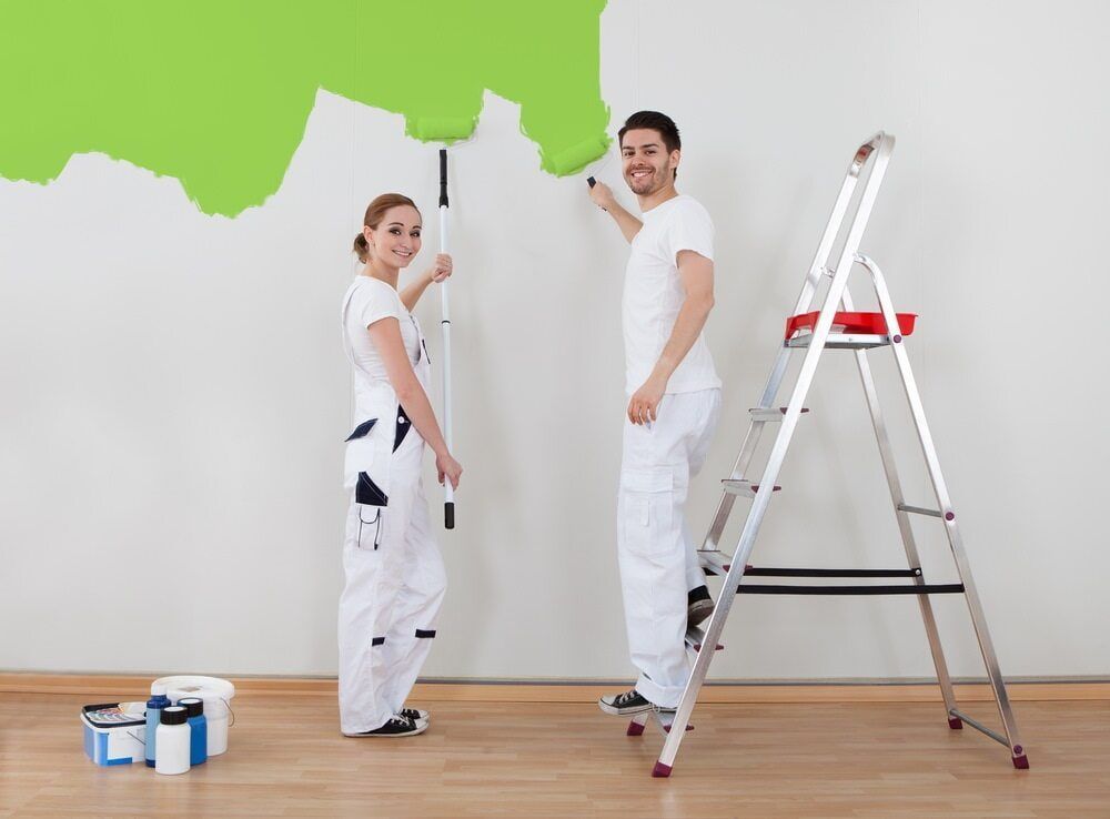 A Man And A Woman Are Painting A Wall Green — Ballina Painting Service In Evans Head, NSW