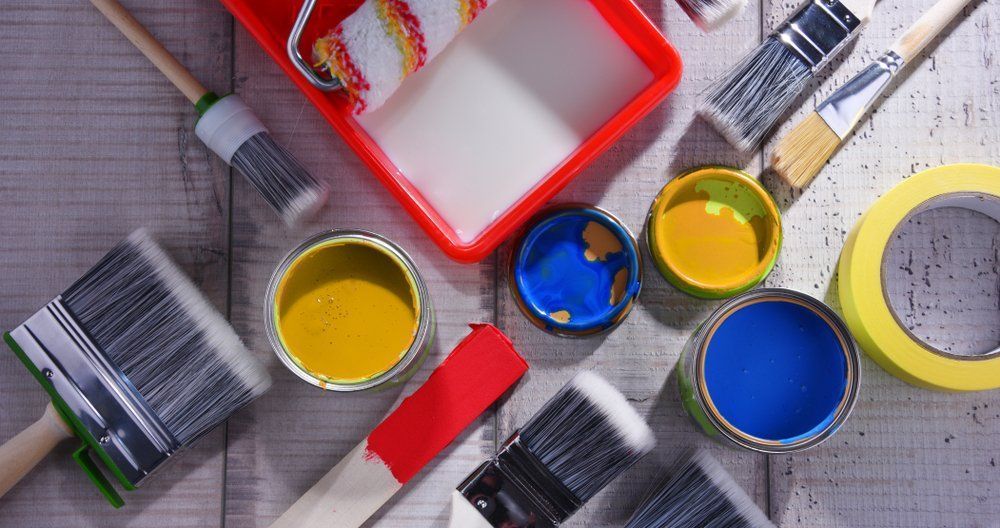 A Bunch Of Paint Cans And Brushes On A Table — Ballina Painting Service In Lismore, NSW