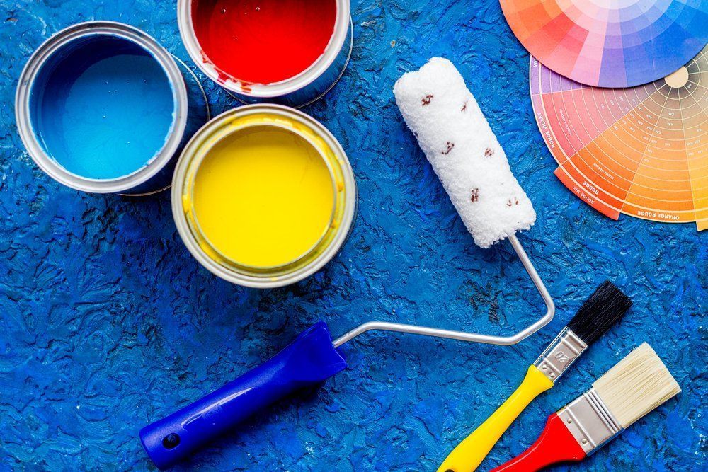 Paint Cans, Paint Rollers, And Brushes On A Blue Surface — Ballina Painting Service In Ballina, NSW