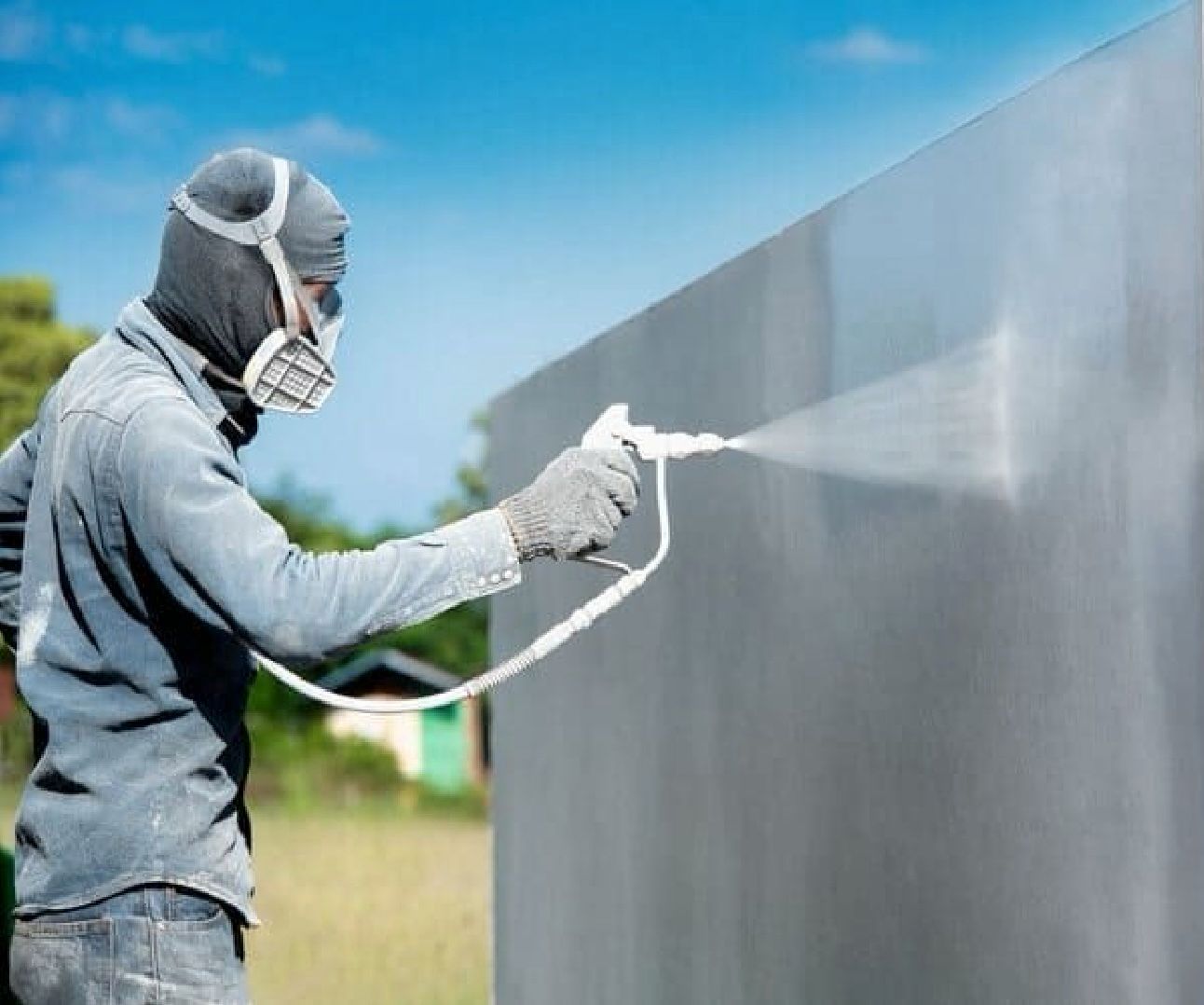 Painter spray painting a wall
