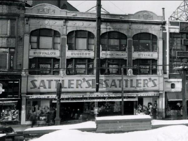A historic black-and-white photo of the Sattler’s department store building facade, featuring large, prominent lettering.