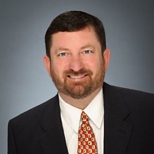 A man in a suit and tie is smiling for the camera.