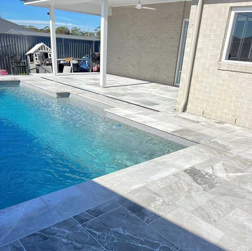 A Large Swimming Pool With A Covered Patio In Front Of A House — Amber North Coast In Port Macquarie, NSW