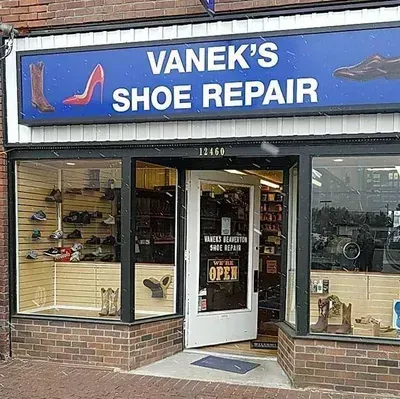 Vanek 's shoe repair is a shoe repair shop located in a brick building.