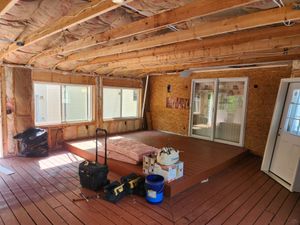 A room with a lot of windows and a wooden floor.