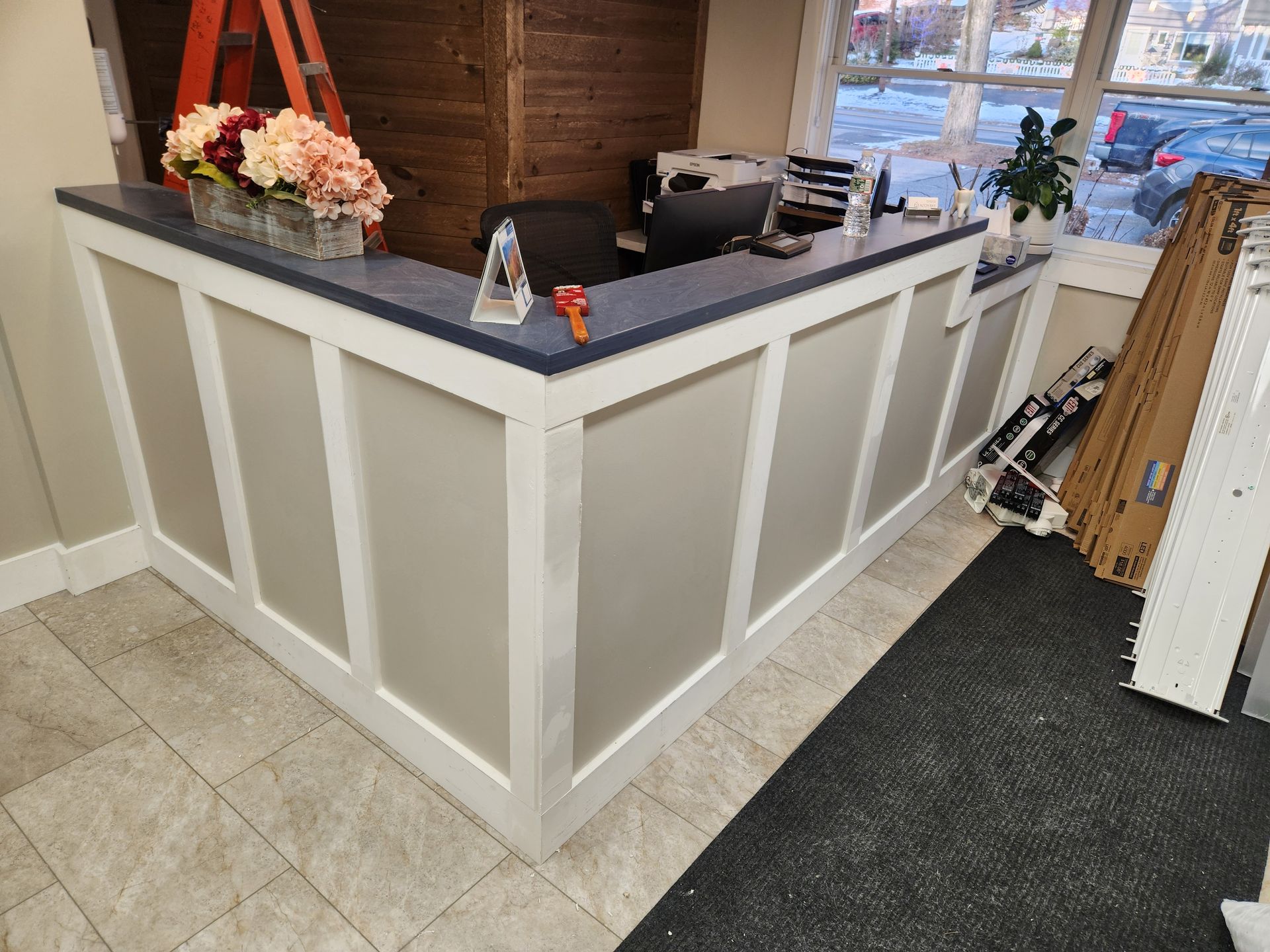 A reception desk with a vase of flowers on top of it.