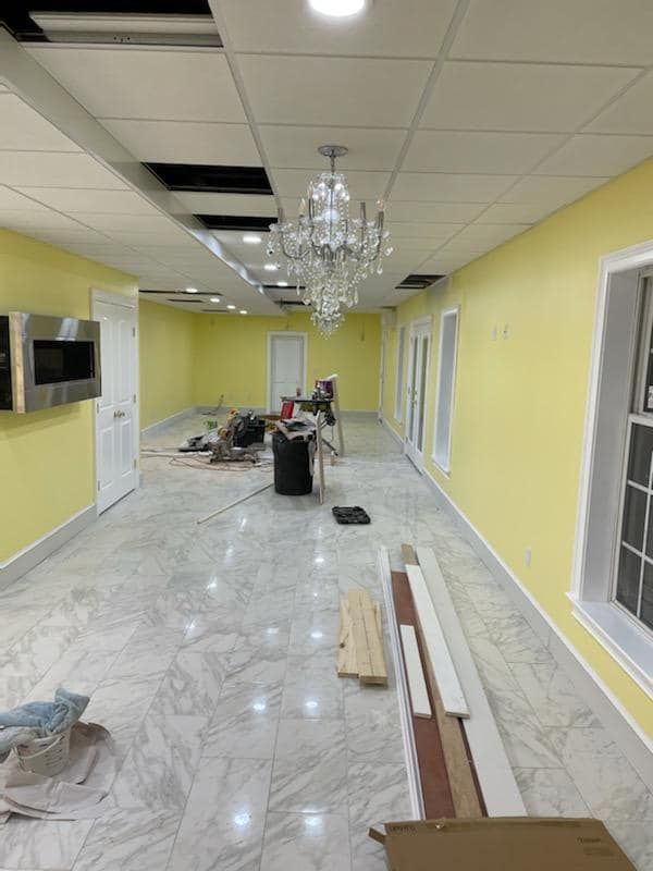 A large room with yellow walls and a chandelier hanging from the ceiling.