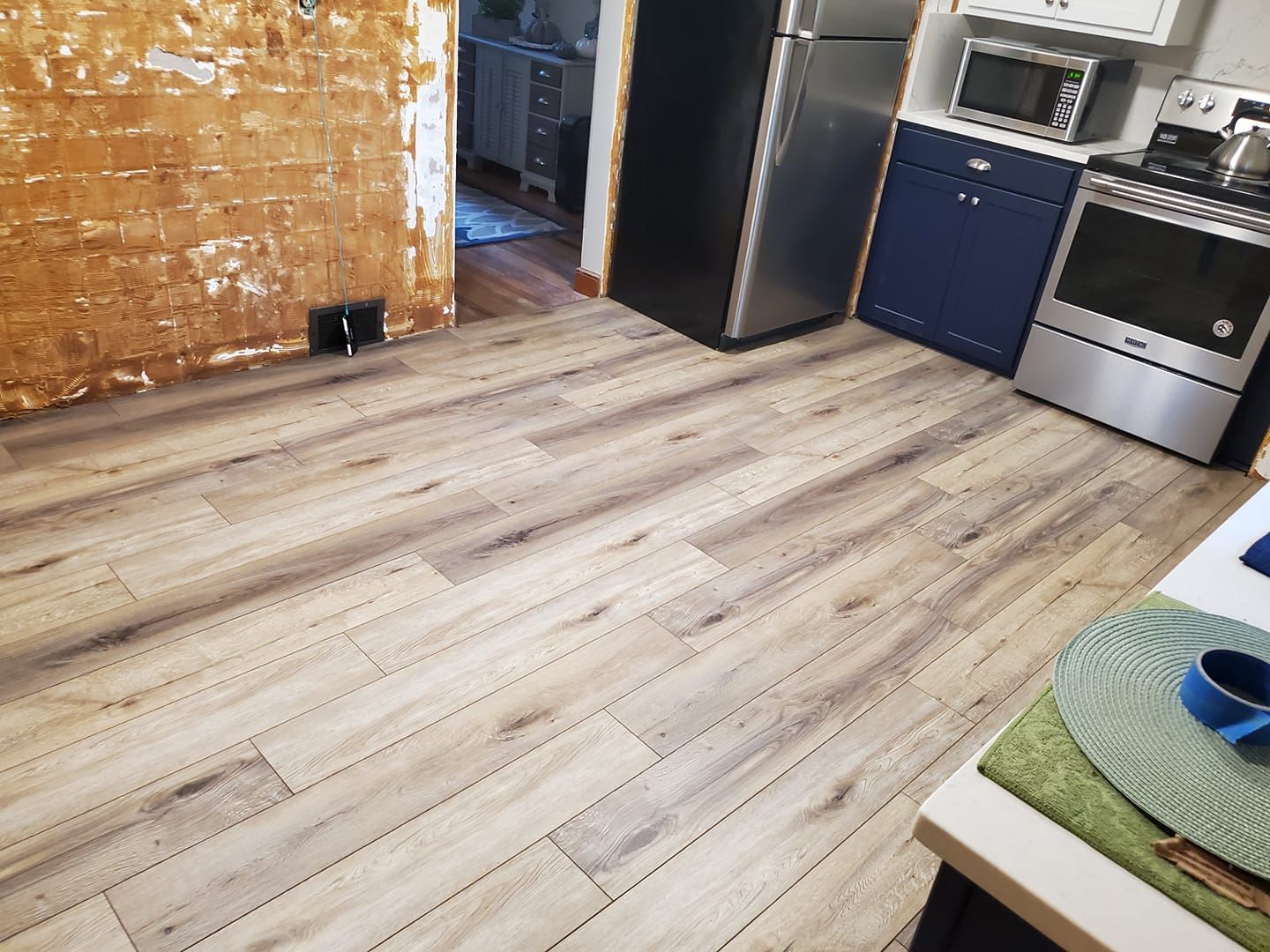 A kitchen with hardwood floors and stainless steel appliances.