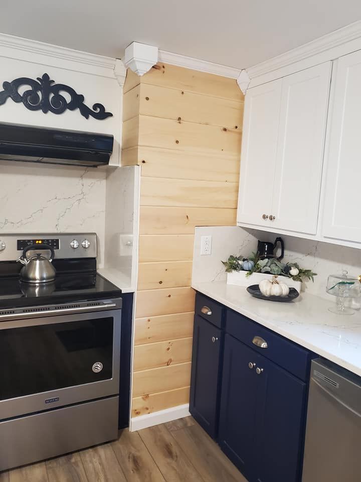 A kitchen with blue cabinets , a stove , and a dishwasher.