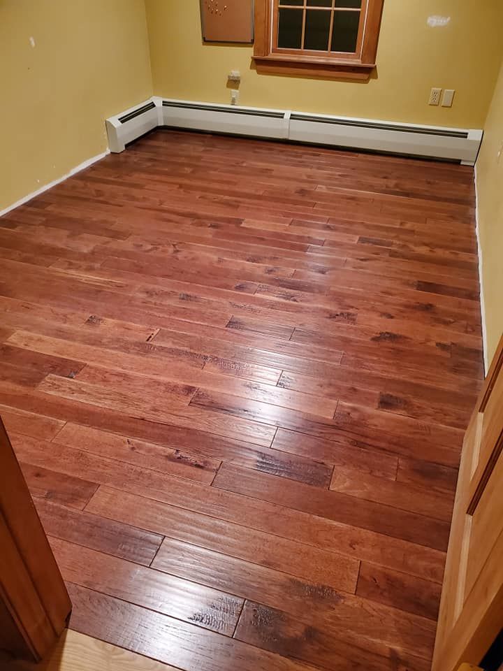 A room with hardwood floors and a window.
