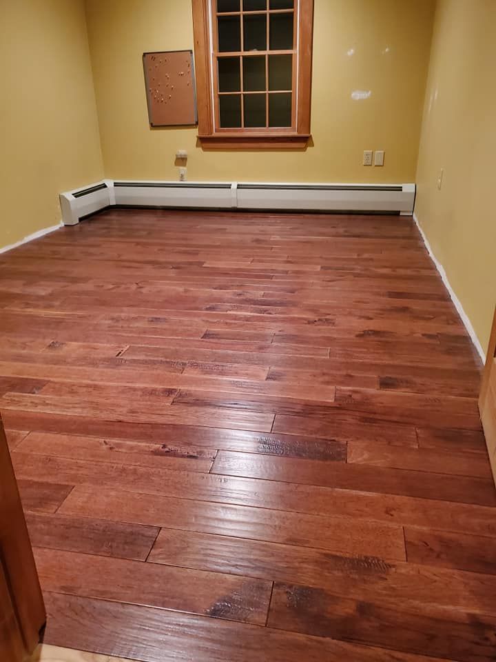 A room with hardwood floors and a window.