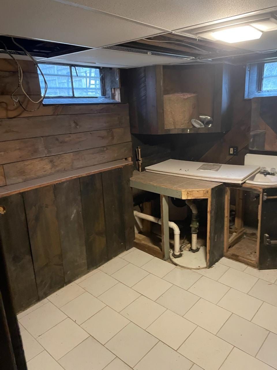 A basement with a sink and a washer and dryer in it.