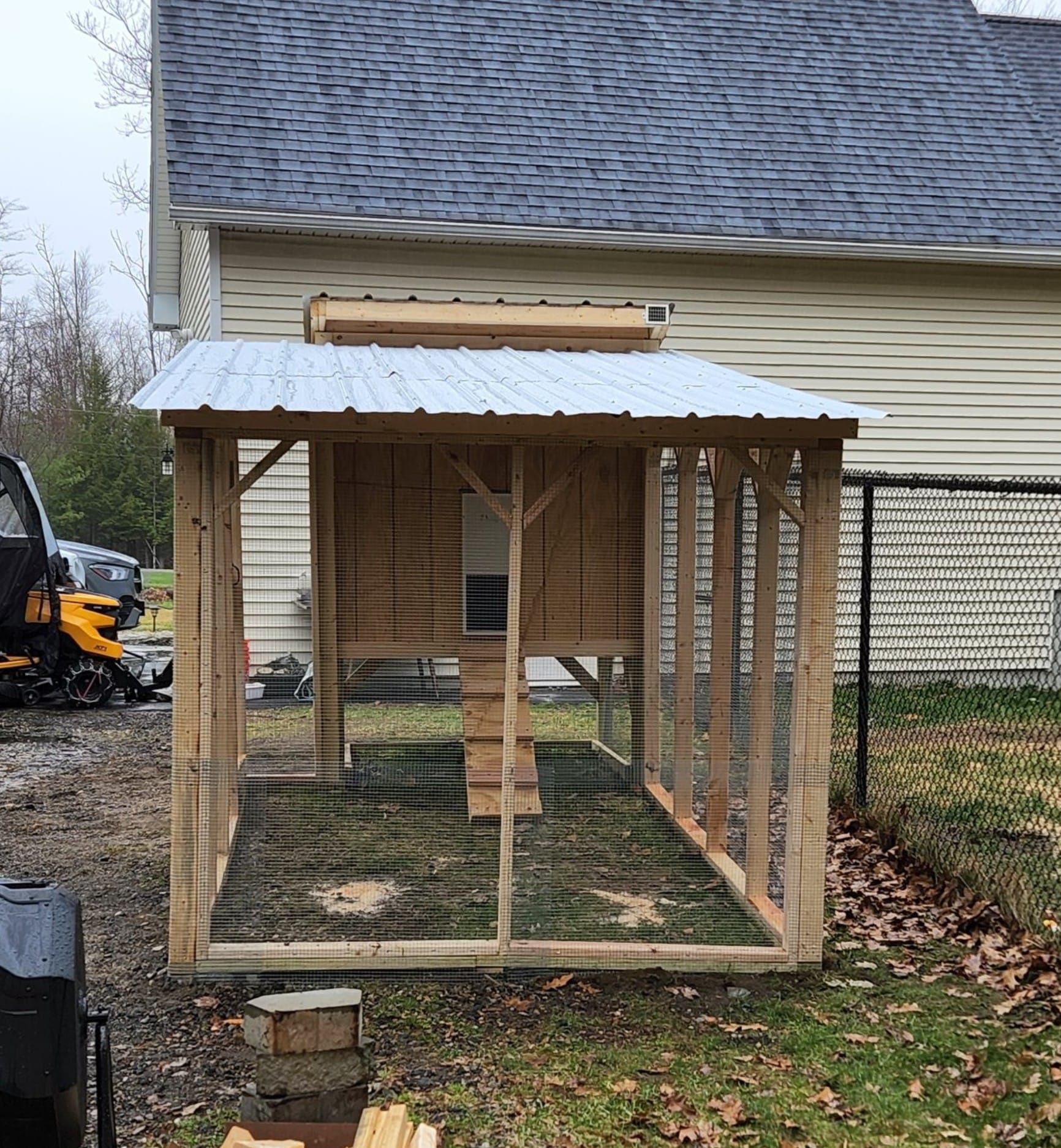 A chicken coop is being built in front of a house.