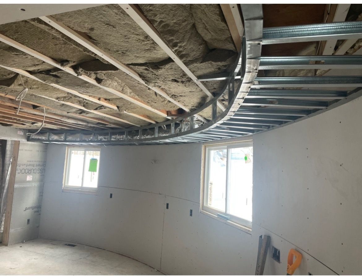 A room with a ceiling that is being built and a lot of windows.