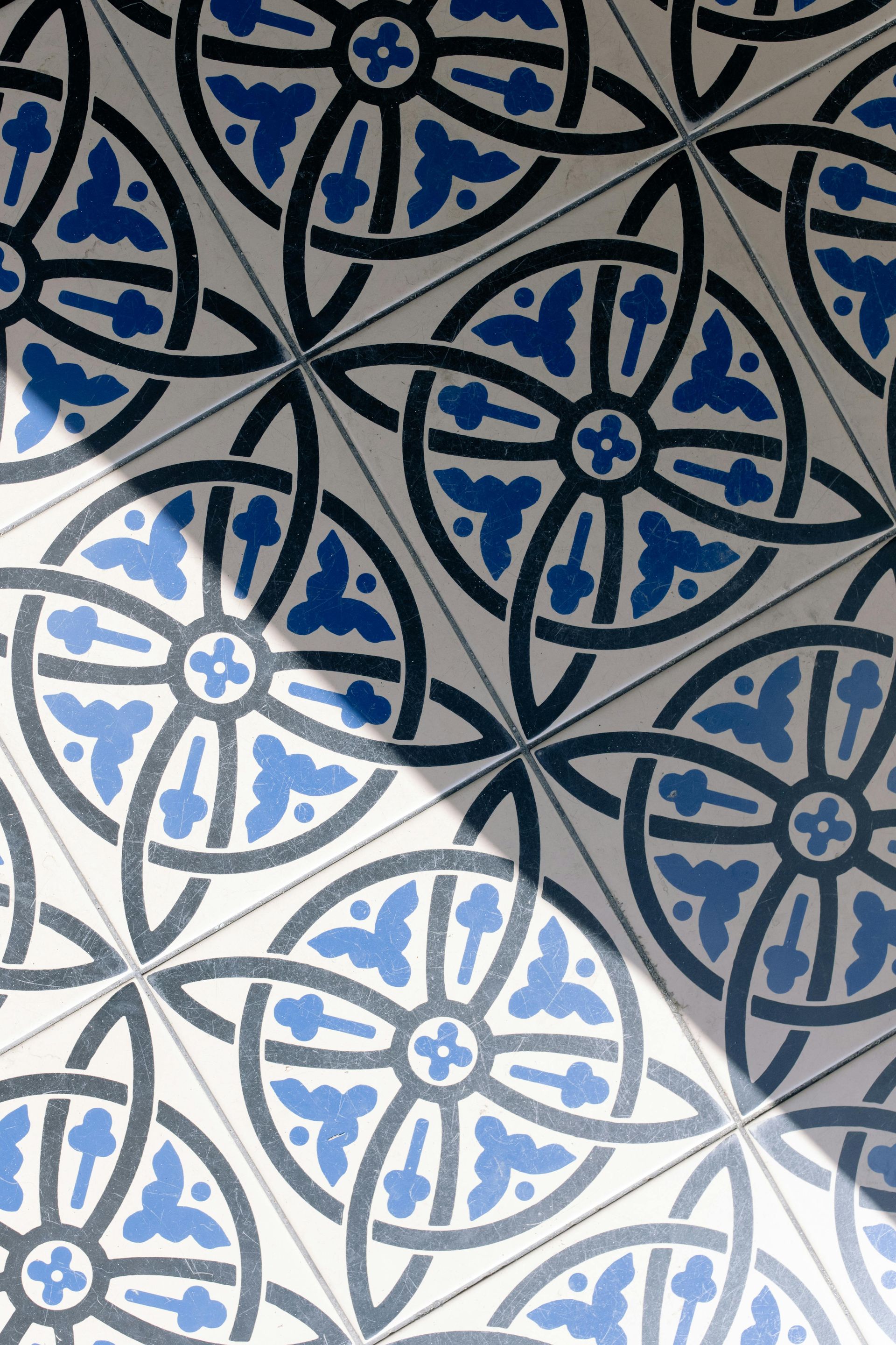 Patterned porcelain tile flooring used as a decorative wall and floor finish in a master bathroom upgrade.