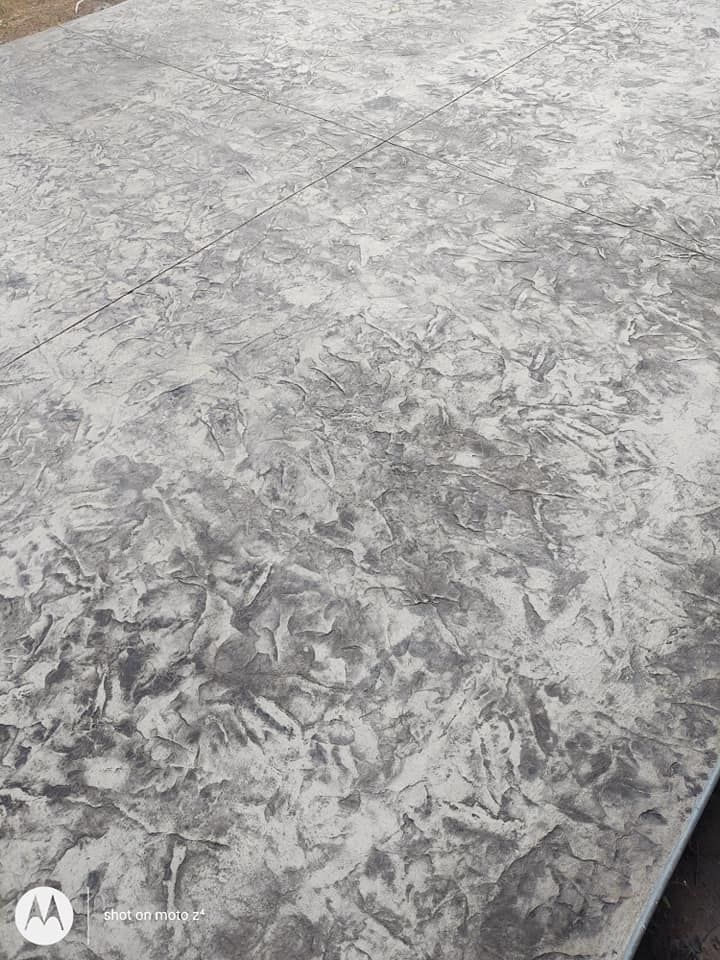 Gray textured concrete surface with mottled white and dark gray patterns, close-up view