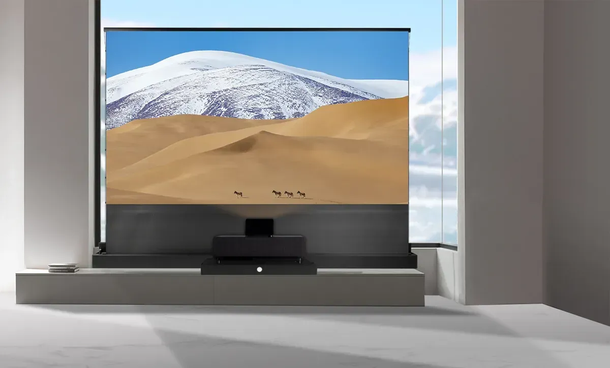 Großer Flachbildfernseher mit Darstellung eines schneebedeckten Berges über Wüstendünen in einem modernen Zimmer