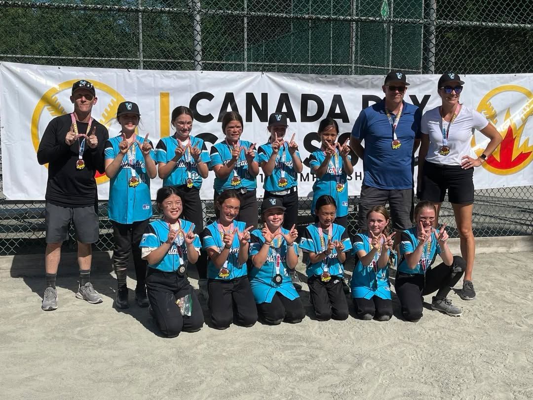 Canada team posing with medals and trophies in front of a Canada banner at an outdoor event.