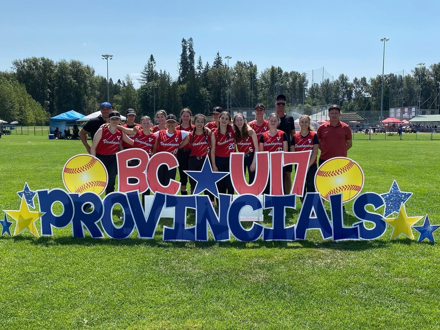 Youth baseball team posing behind “BC U17 Provincials” sign on a sunny field