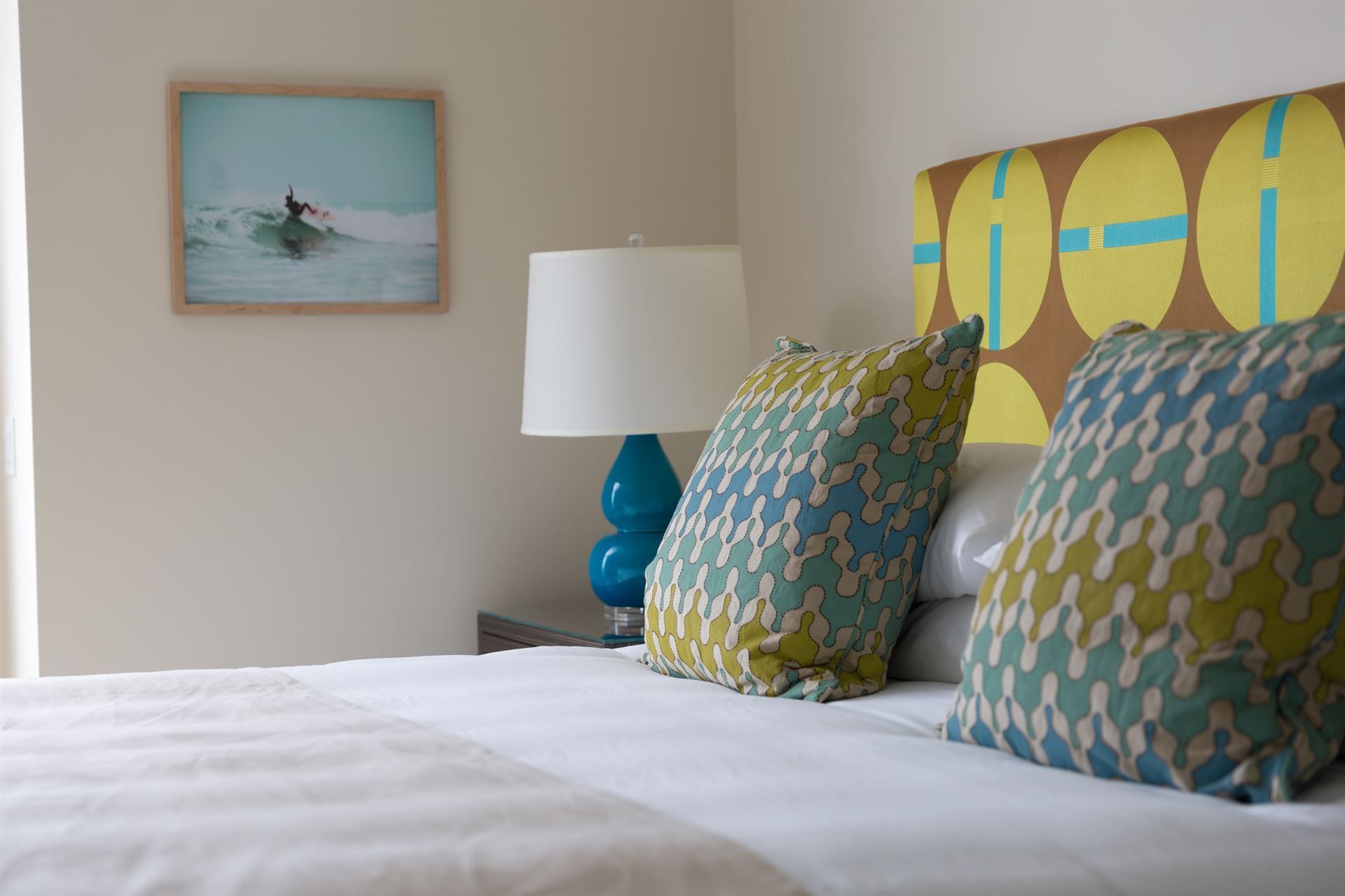 A bed with a picture on the wall above it