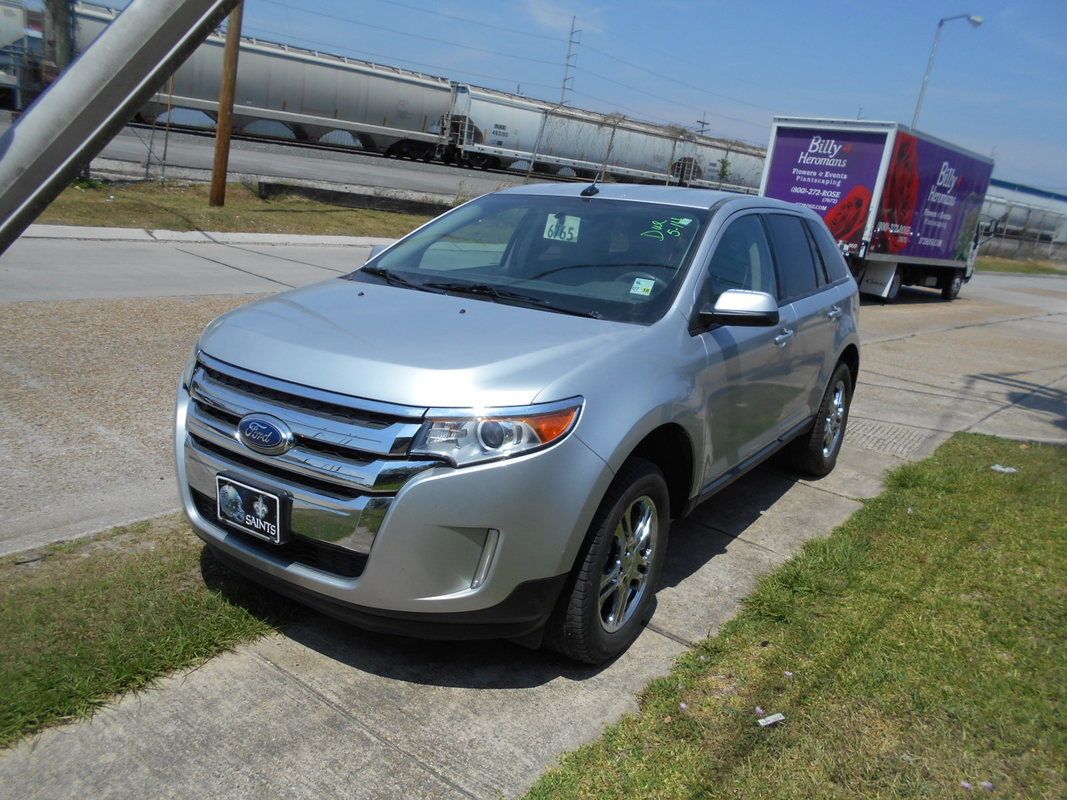 A silver ford edge is parked on the side of the road